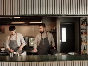 Two hospitality workers on shift in the kitchen