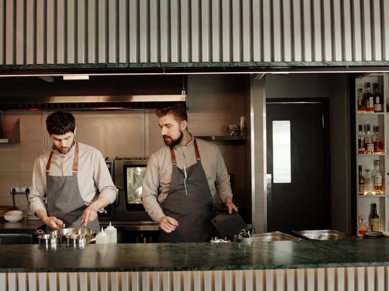 Two hospitality workers on shift in the kitchen